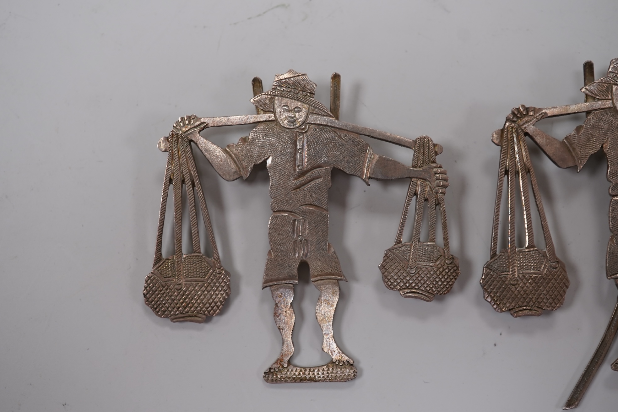 A Chinese Export white metal matchbox holder, with Chinese character mark stamp, embossed and engraved with dragon and prunus, 60mm and a pair of white metal figural menu holders, unmarked.